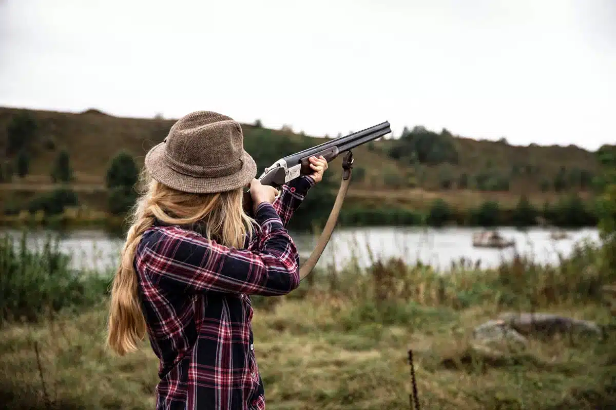 Jägerin zielt mit einem Gewehr